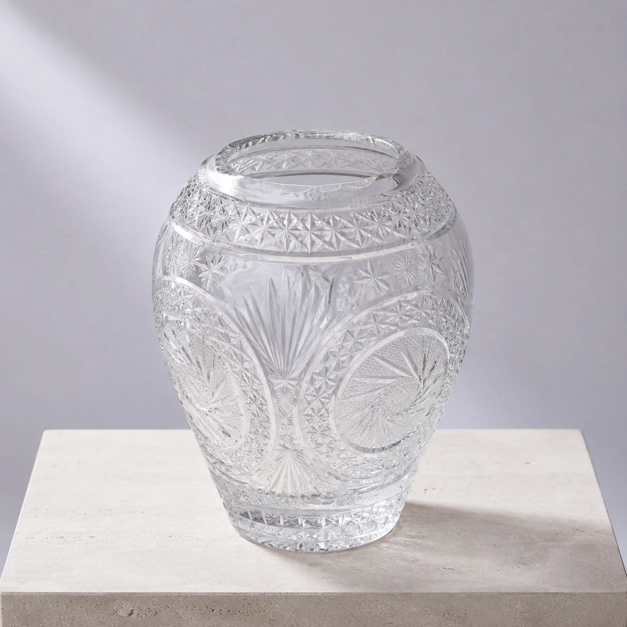 Starburst cut crystal vase with a rounded body and open neck